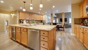 Una cocina amplia con armarios de madera, encimera de granito y una isla central con fregadero.