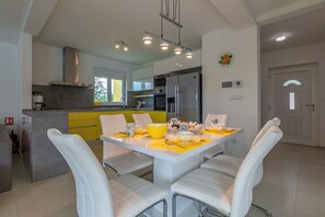 Enjoy meals in the kitchen and dining area, featuring a stove, refrigerator, and oven, and a dining table with four chairs.