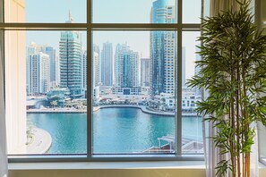 A view from a window overlooking a marina with tall buildings in the background. - Nasma Luxury Stays - Park Island Blakely (Dubai)
