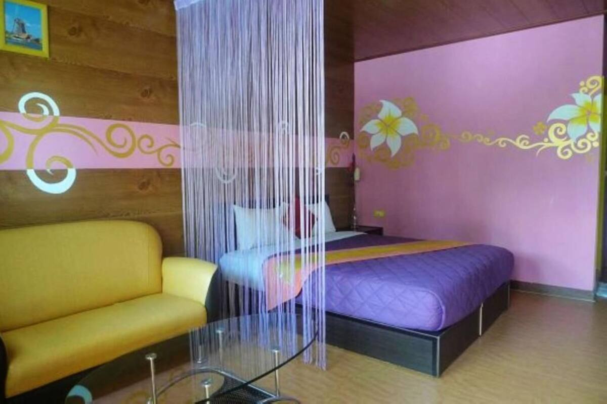 Um quarto com uma cama, um sofá e uma mesa de vidro.