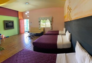 A room with two beds, a television on the wall, a window with curtains, and a small table with chairs. - J Lin Hostel (Hengchun)