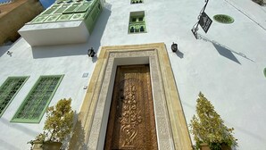 A building with a large ornate door, green window frames, and a white facade. - Dar El Kif La Marsa (La Marsa)