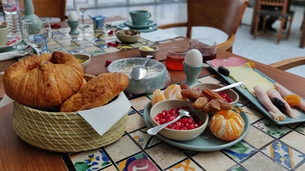 A breakfast table with croissants, pomegranate seeds, oranges, and various spreads. - Dar El Kif La Marsa (La Marsa)