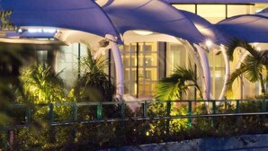 A modern building with a distinctive dome structure and multiple covered areas. - Grass Residences - Condo (Quezon City)