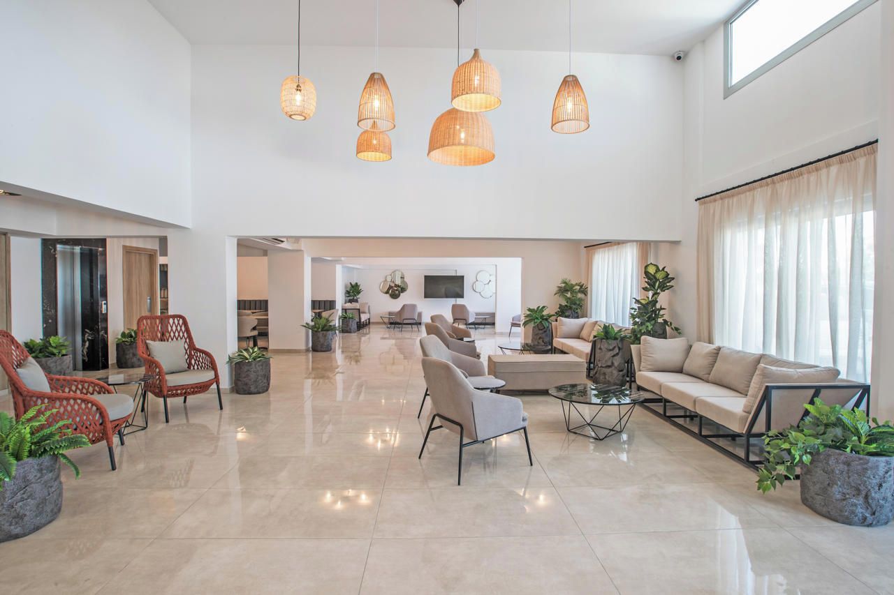 A spacious lobby with a high ceiling, multiple seating areas, and a central coffee table.