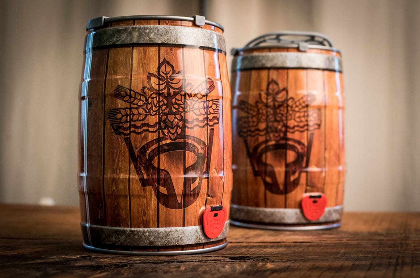 Two wooden barrels with embossed designs on a wooden surface.