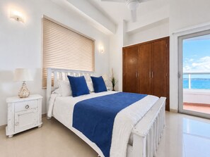 A bedroom with a bed, bedside table, lamp, wardrobe, and a view of the sea through a balcony. - Charming • Lovely view • Beach • Pool 901 (Cartagena)