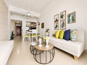 A modern living room with a white sofa, a round coffee table, and a dining area with a white table and chairs. - Charming • Lovely view • Beach • Pool 901 (Cartagena)