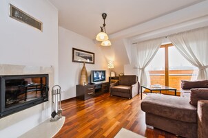 Una sala de estar moderna con chimenea, televisor y asientos cómodos.