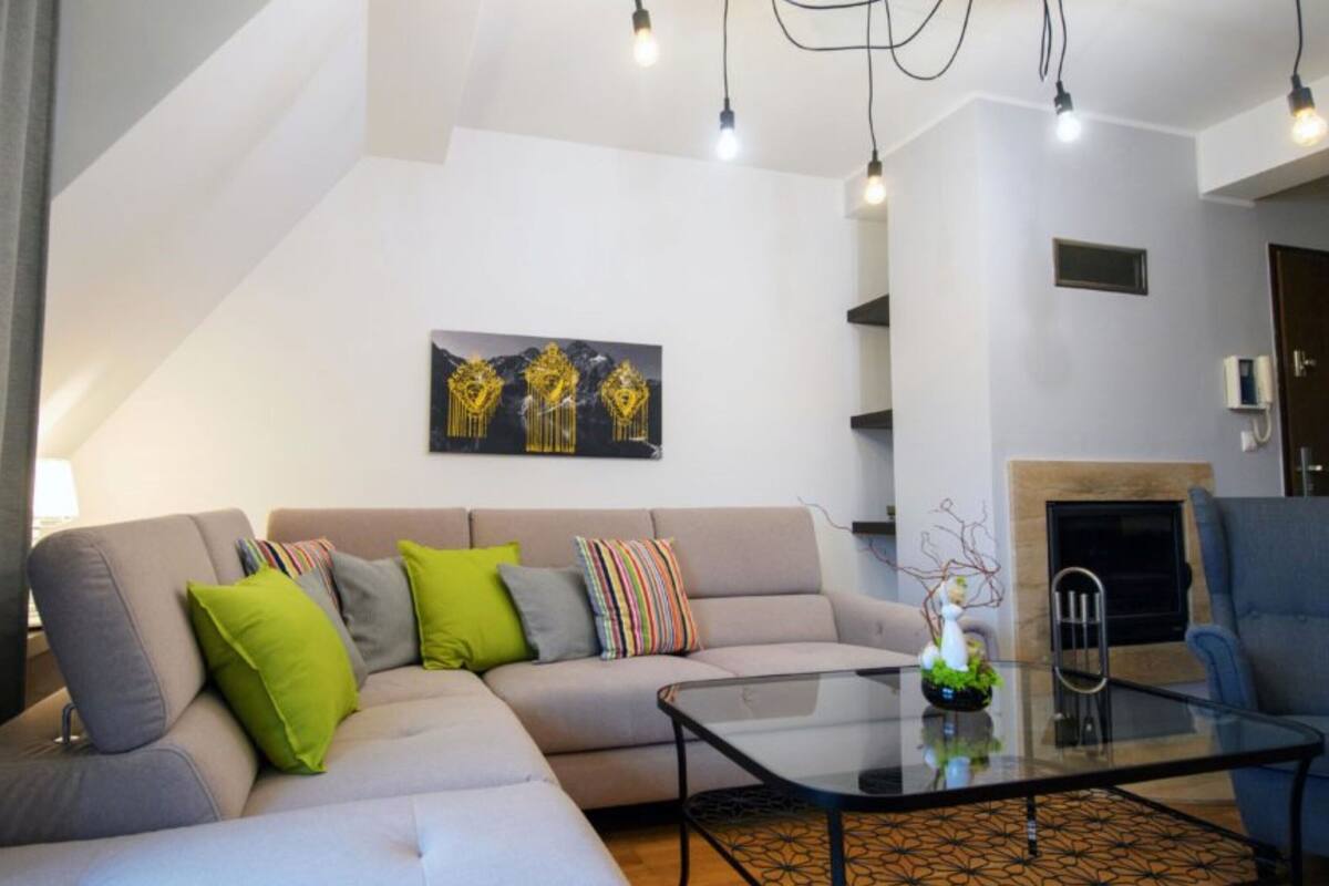 A modern living room with a sofa, coffee table, and a fireplace.
