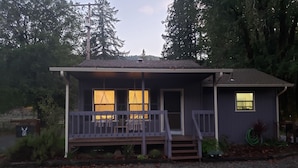 A small house with a porch, two windows, and a door.