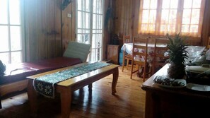 A wooden room with a bed, a bench, a dining table with chairs, and a window with curtains. - Big Dipper Sagada (Sagada)