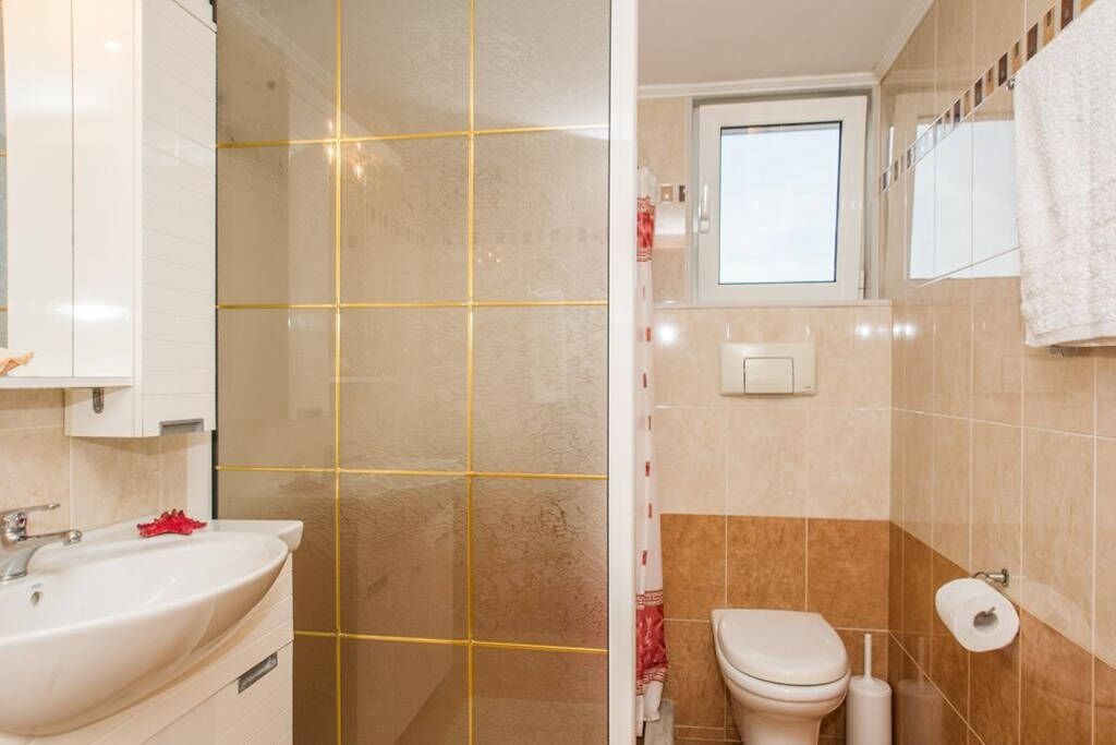 A bathroom with a sink, toilet, and shower area.