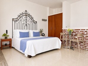 A bedroom with a bed, bedside table, nightstand, and a brick wall. - Lovely view • Private terrace • Beach • Pool 1404B (Cartagena)