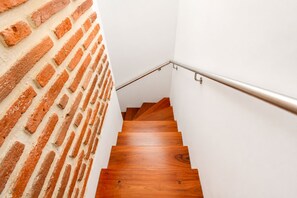 A wooden staircase with a metal handrail, adjacent to a brick wall. - Lovely view • Private terrace • Beach • Pool 1404B (Cartagena)