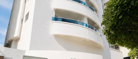 A modern building with a curved facade, numbered 3-109, and a sign reading 'Mirador del LAGUITO'.
