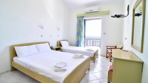 Une chambre d’hôtel avec deux lits, un bureau, une chaise et un balcon avec vue.