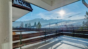 Ein Balkon mit Blick auf schneebedeckte Berge und einen klaren Himmel.