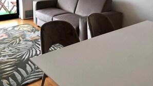 Un salon moderne avec un canapé gris, une petite table et un tapis à motifs.