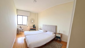Une chambre avec deux lits, un bureau et une chaise.