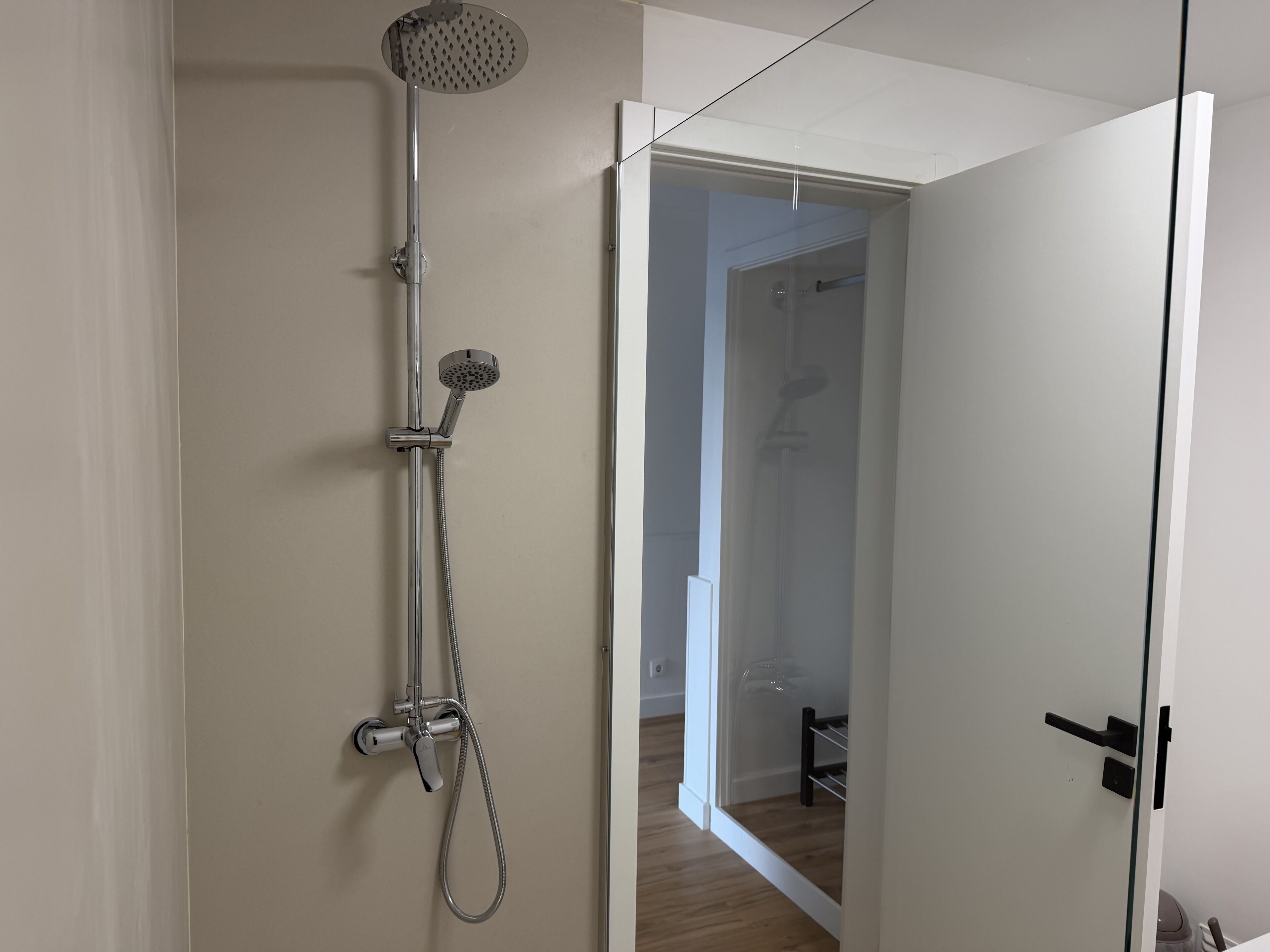 A modern bathroom with a shower, a toilet, and a sink.