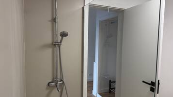 A modern bathroom with a shower, a toilet, and a sink.