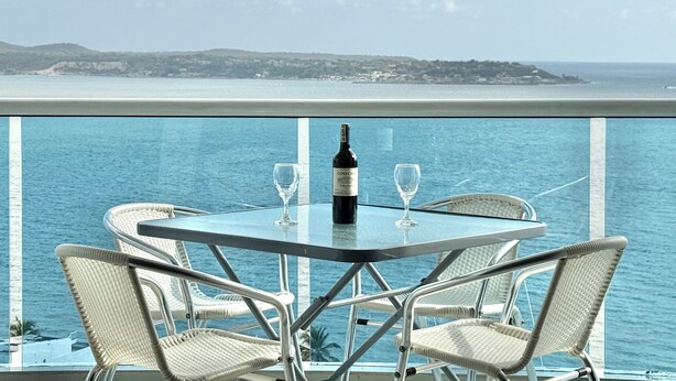 A table with two chairs and a bottle of wine on a balcony overlooking the sea. - Ocean view • Wonderful sunsets • Beach • Pool 1206 (Cartagena)