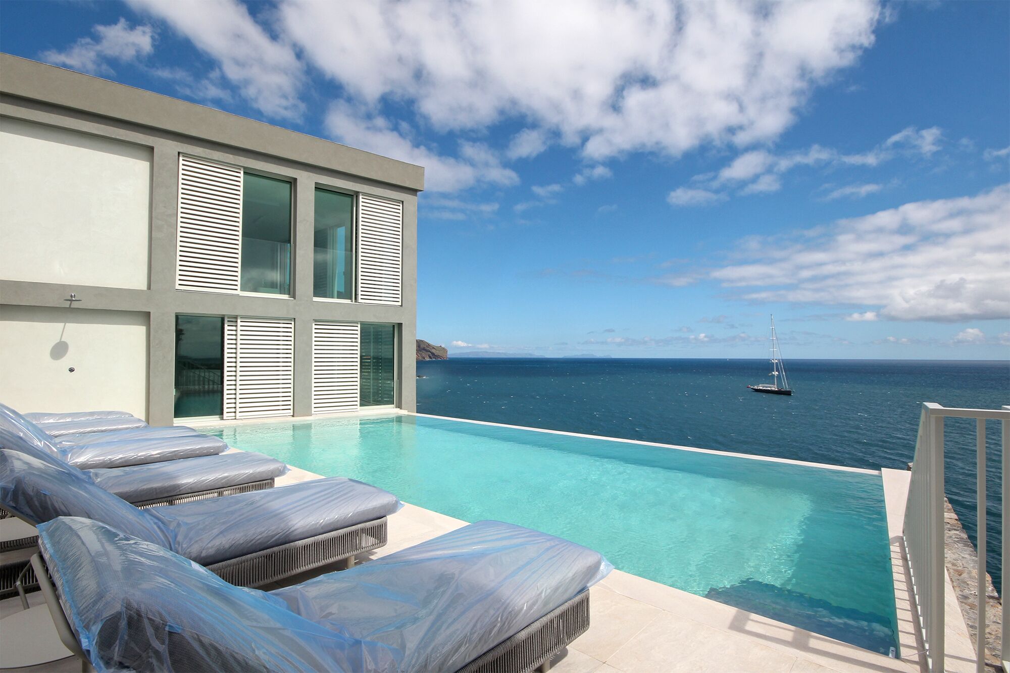 Una piscina al aire libre, sillones reclinables de piscina