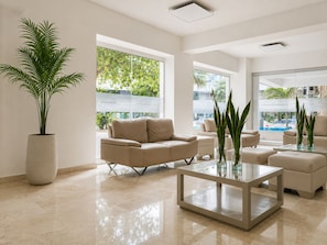 A modern living room with a beige sofa, a glass coffee table, and a potted plant. - Penthouse • Private pool • Ocean view • Beach 1803 (Cartagena)