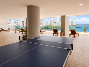 A ping pong table in a spacious indoor area with multiple lounge chairs and potted plants. - Penthouse • Private pool • Ocean view • Beach 1803 (Cartagena)