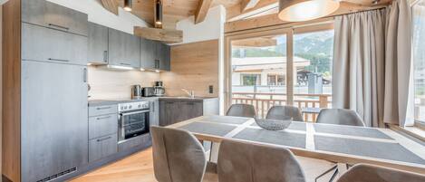 A modern kitchen with grey cabinets and a dining area with a table and chairs.