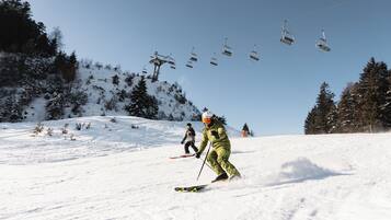 A ski slope with a ski lift and skiers.