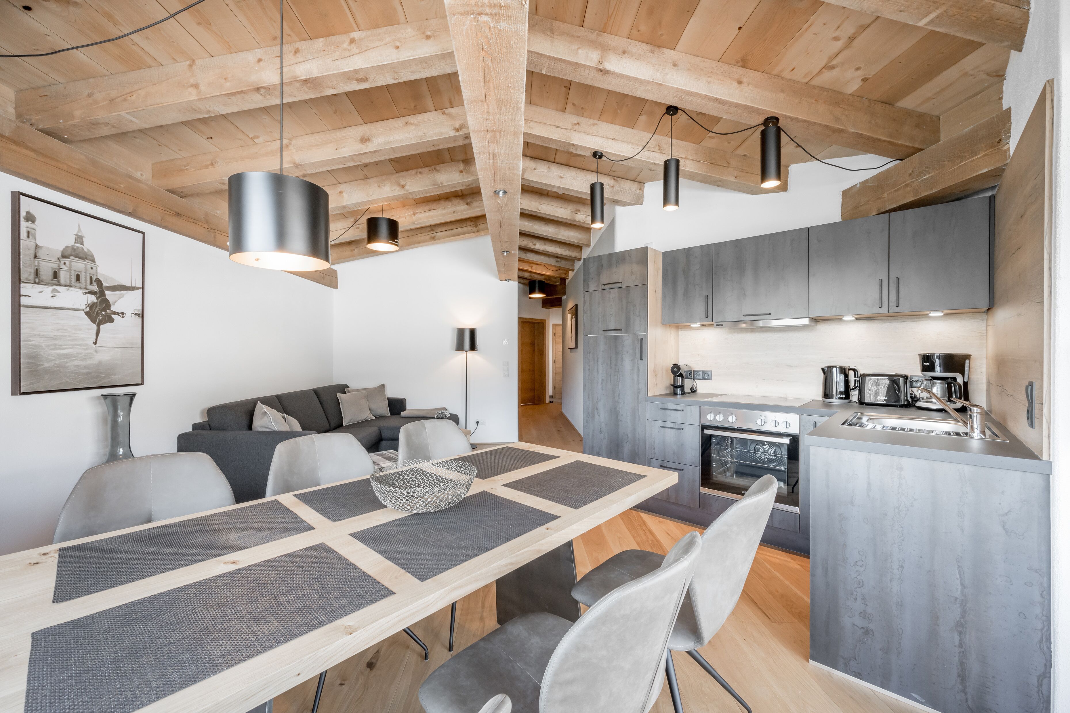 A modern kitchen with grey cabinets, a built-in oven, and a sink.