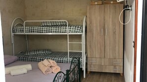 A small, compact room with a bunk bed, a wooden wardrobe, and a wall-mounted TV. - Semi-detached villa a few steps from the sea (San Foca)