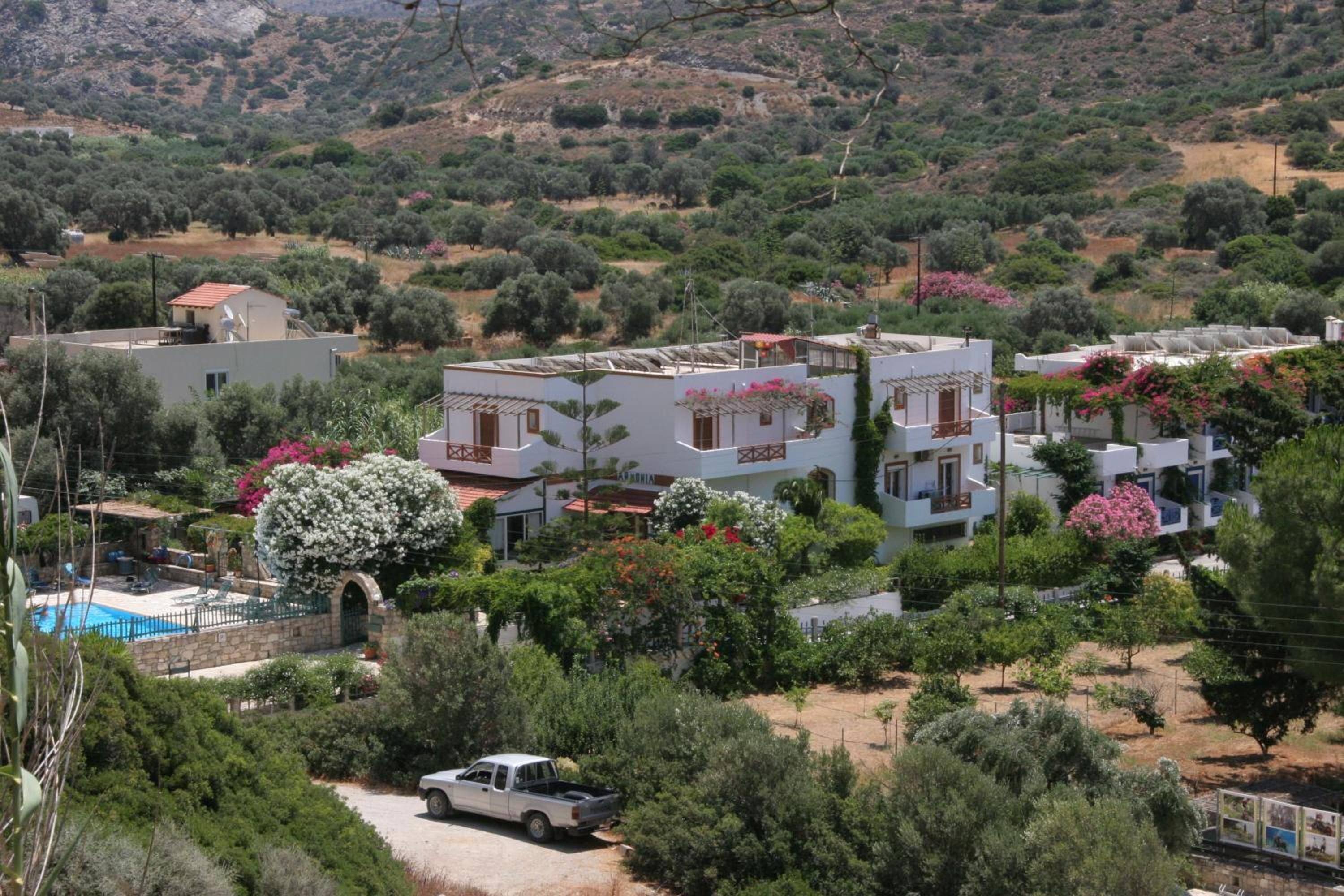 Un barrio residencial con casas modernas, una piscina y una camioneta estacionada.