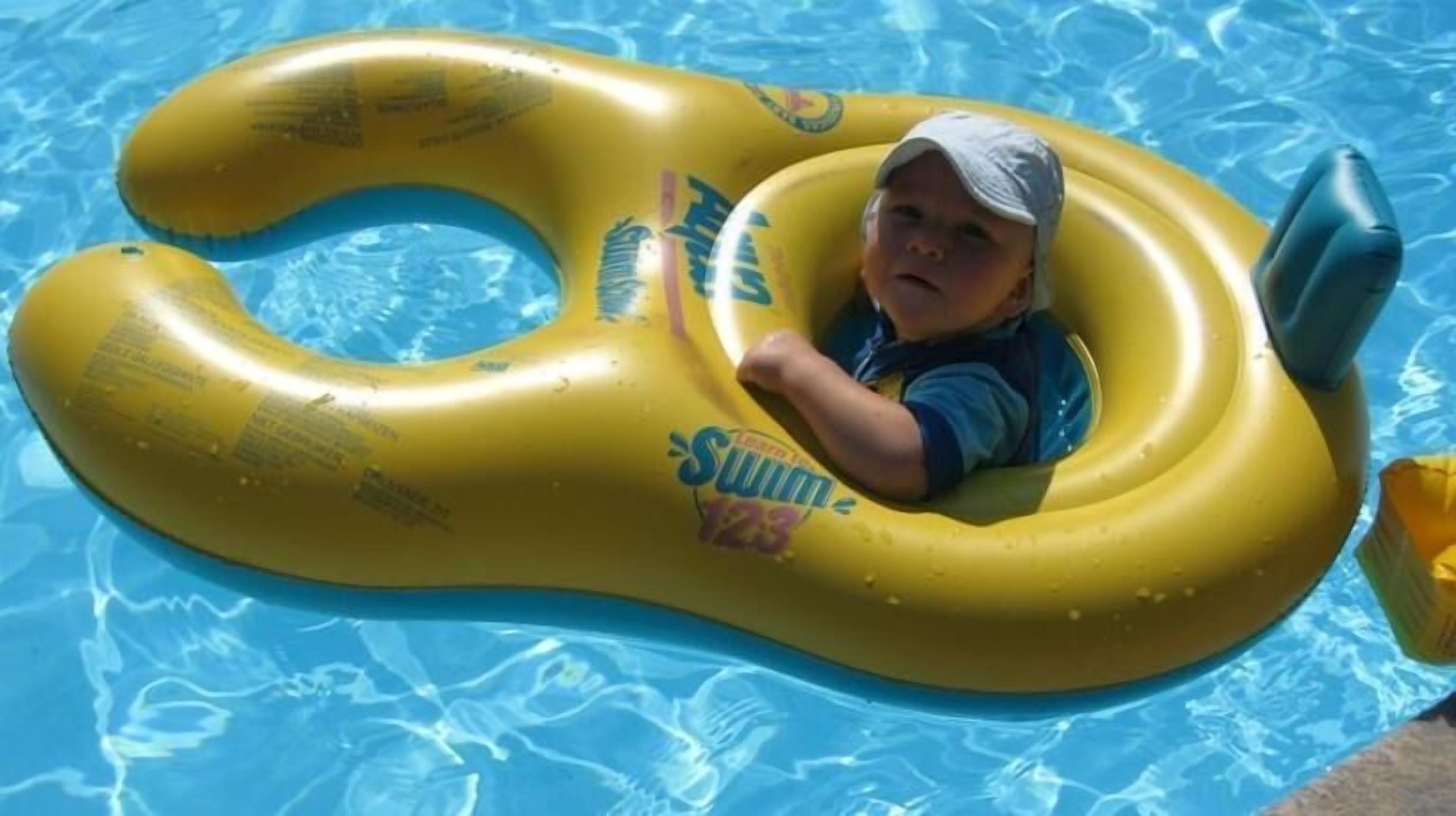 A child in a yellow swim ring in a pool.