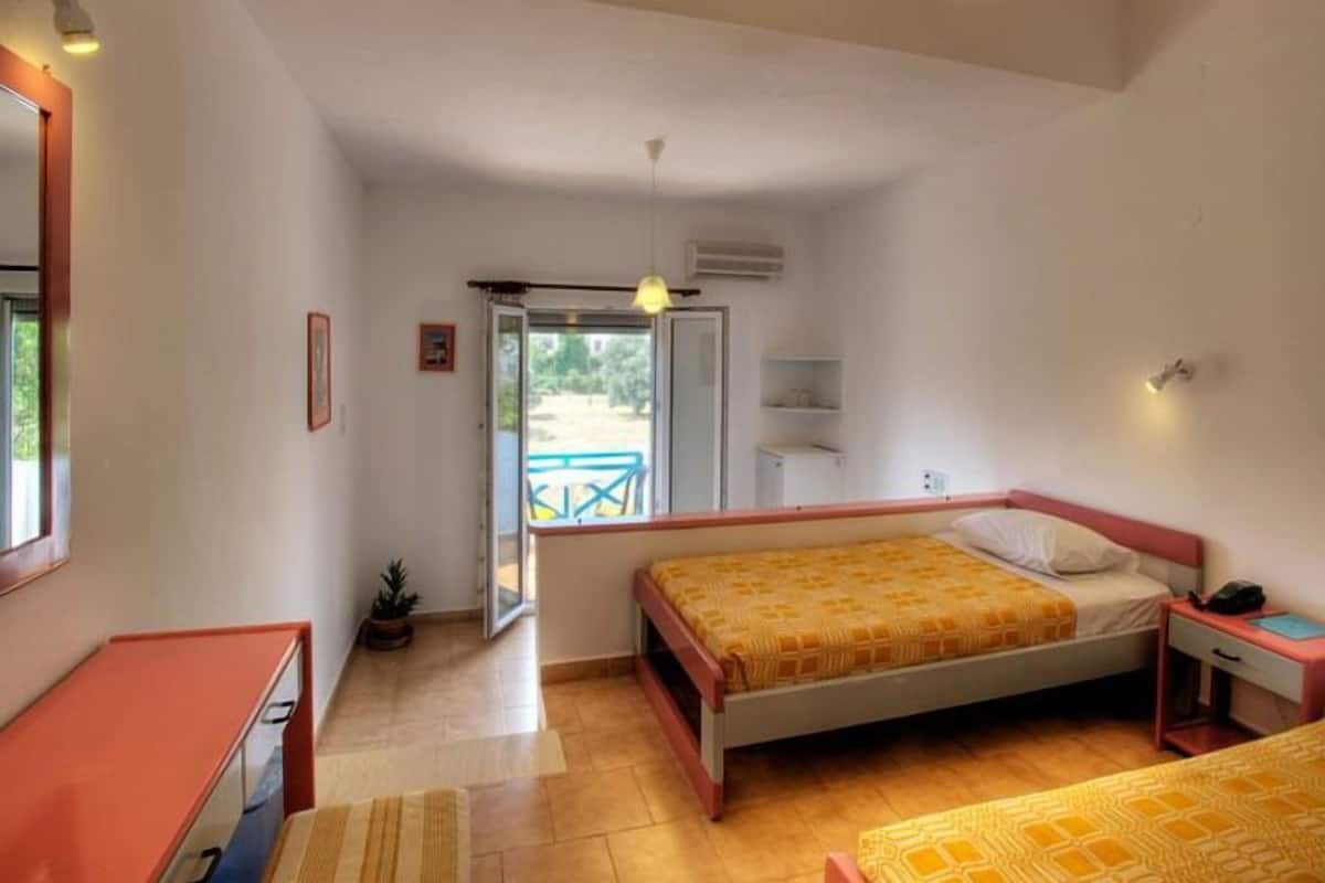 Quarto com cama, mesa de cabeceira e janela.