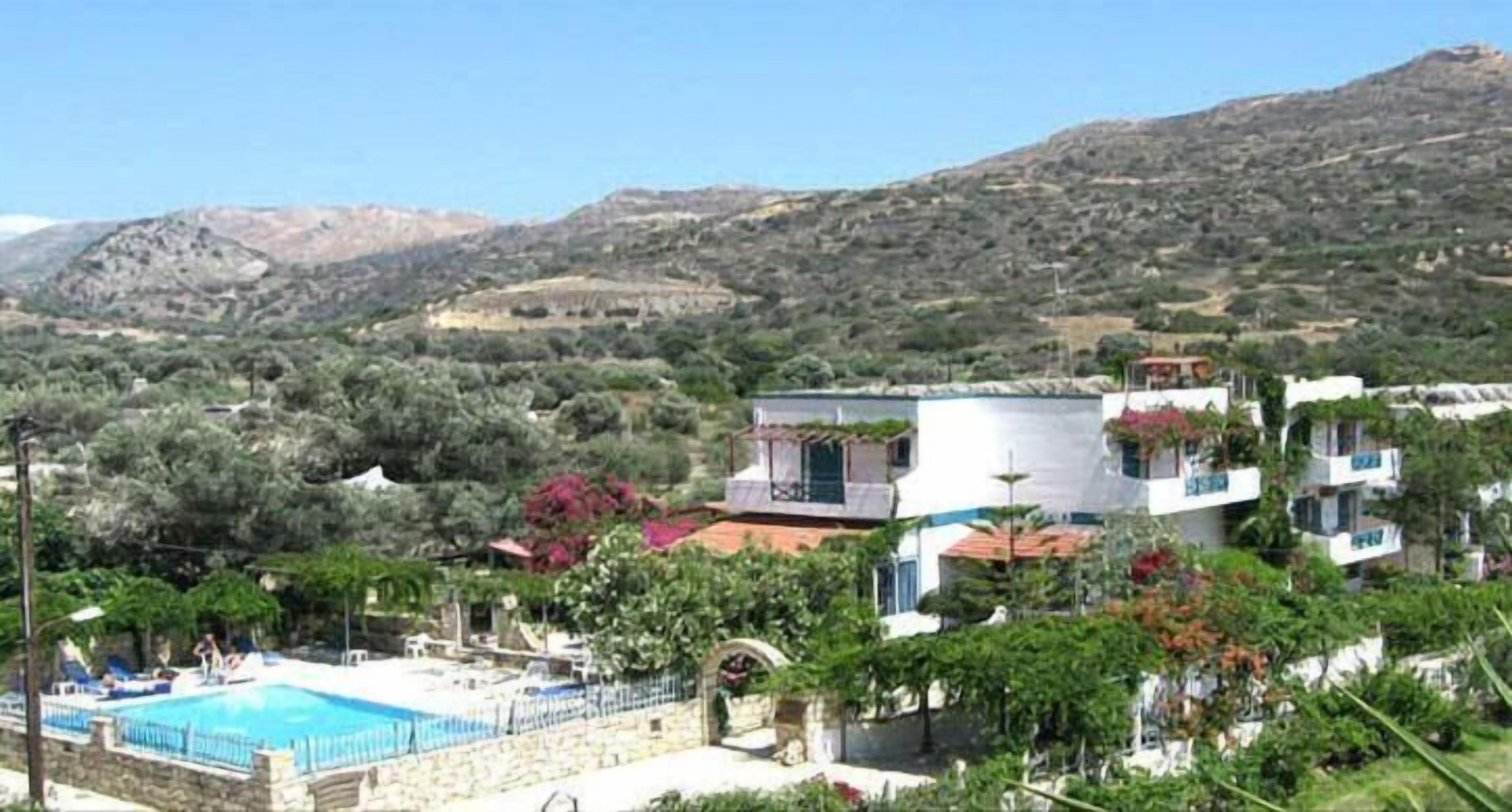 Un hôtel doté d’une piscine, entouré de verdure et de collines.