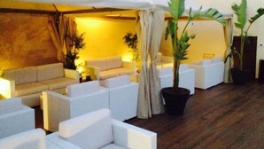 A modern lounge area with white sofas and potted plants. - B&B Le Parmente (Casarano)