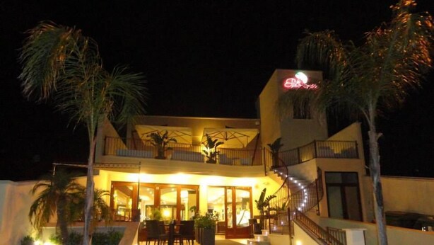 A two-story building with a balcony and outdoor seating area. - B&B Le Parmente (Casarano)