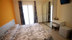 A bedroom with a bed, a desk, a mirror, and a television. - B&B Le Parmente (Casarano)