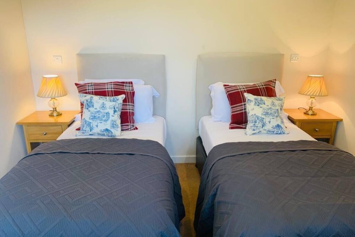 Two twin beds with matching headboards, bedside lamps, and patterned pillows.