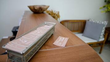A wooden table with a decorative tray and a card.