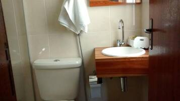 Une petite salle de bain avec des toilettes, un lavabo et un miroir.