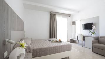 Una habitación de hotel moderna con cama, escritorio, televisor y baño.
