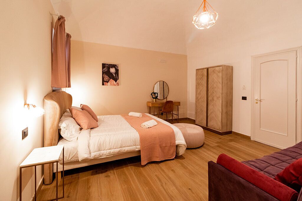 Une chambre à coucher comprenant un lit, une table de chevet, une chaise, une armoire et un bureau avec une chaise.