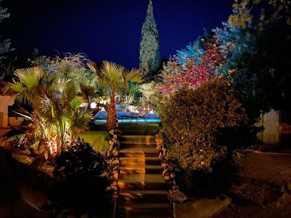 A nighttime garden with a pool, stone steps, and various plants. - NEW - Villa with private pool, beach and shops within walking distance-Golfe de Saint Tropez (Grimaud)