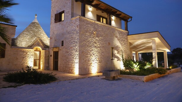 Un edificio de piedra con techo cónico y una extensión moderna.