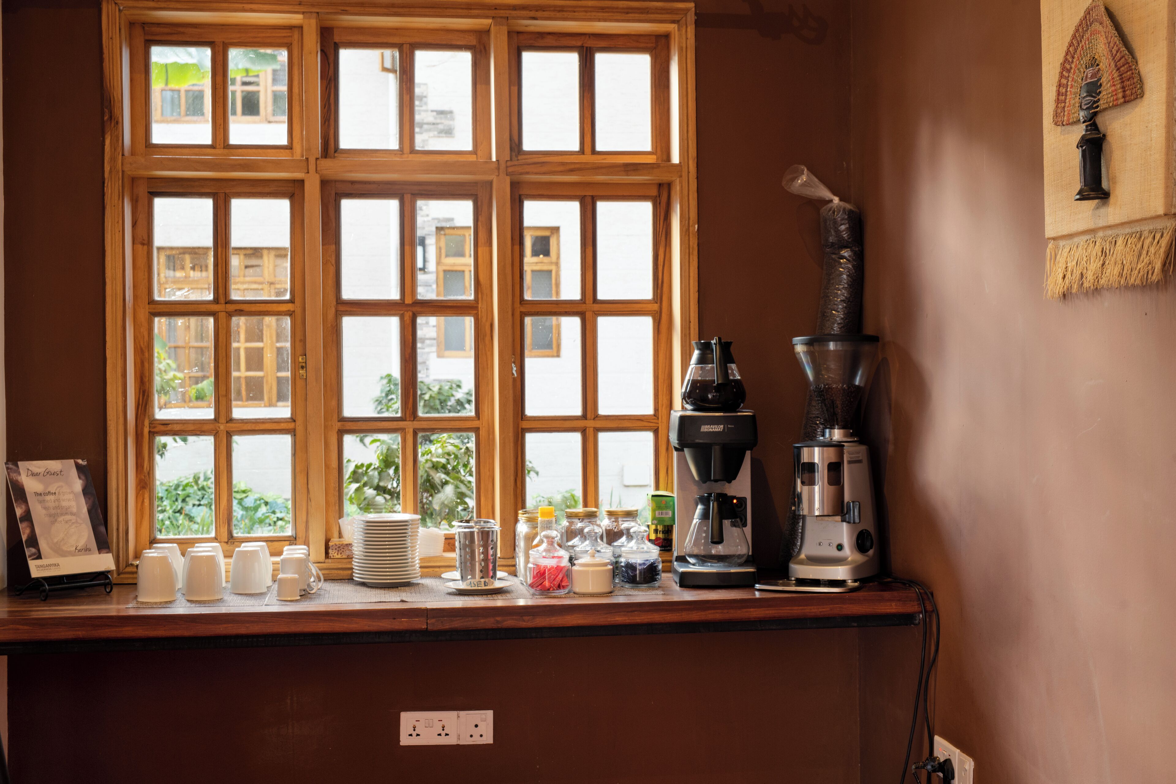 A kitchen counter with a coffee maker, a grinder, and various containers.