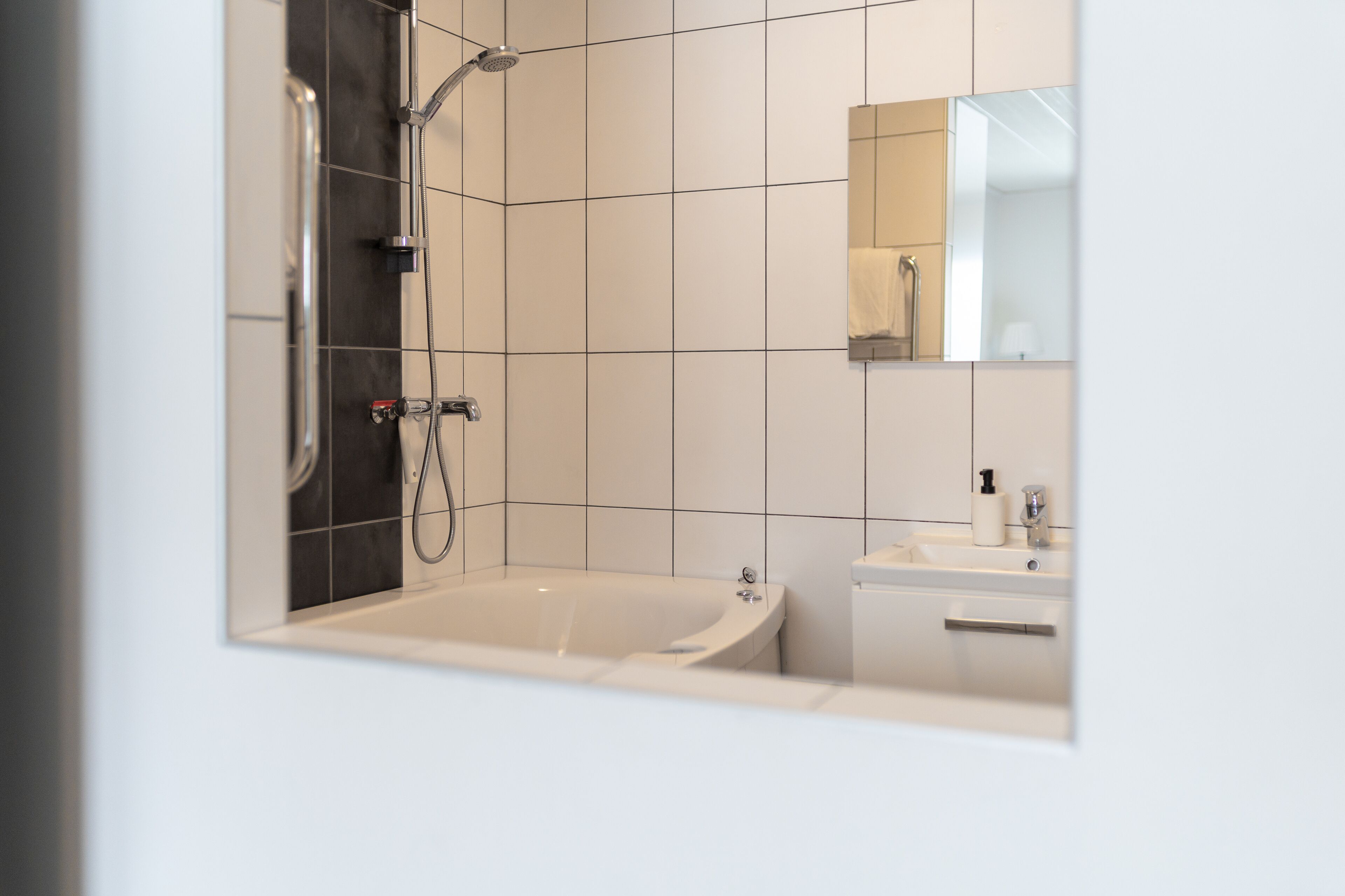 A modern bathroom with a bathtub, a shower, and a sink.